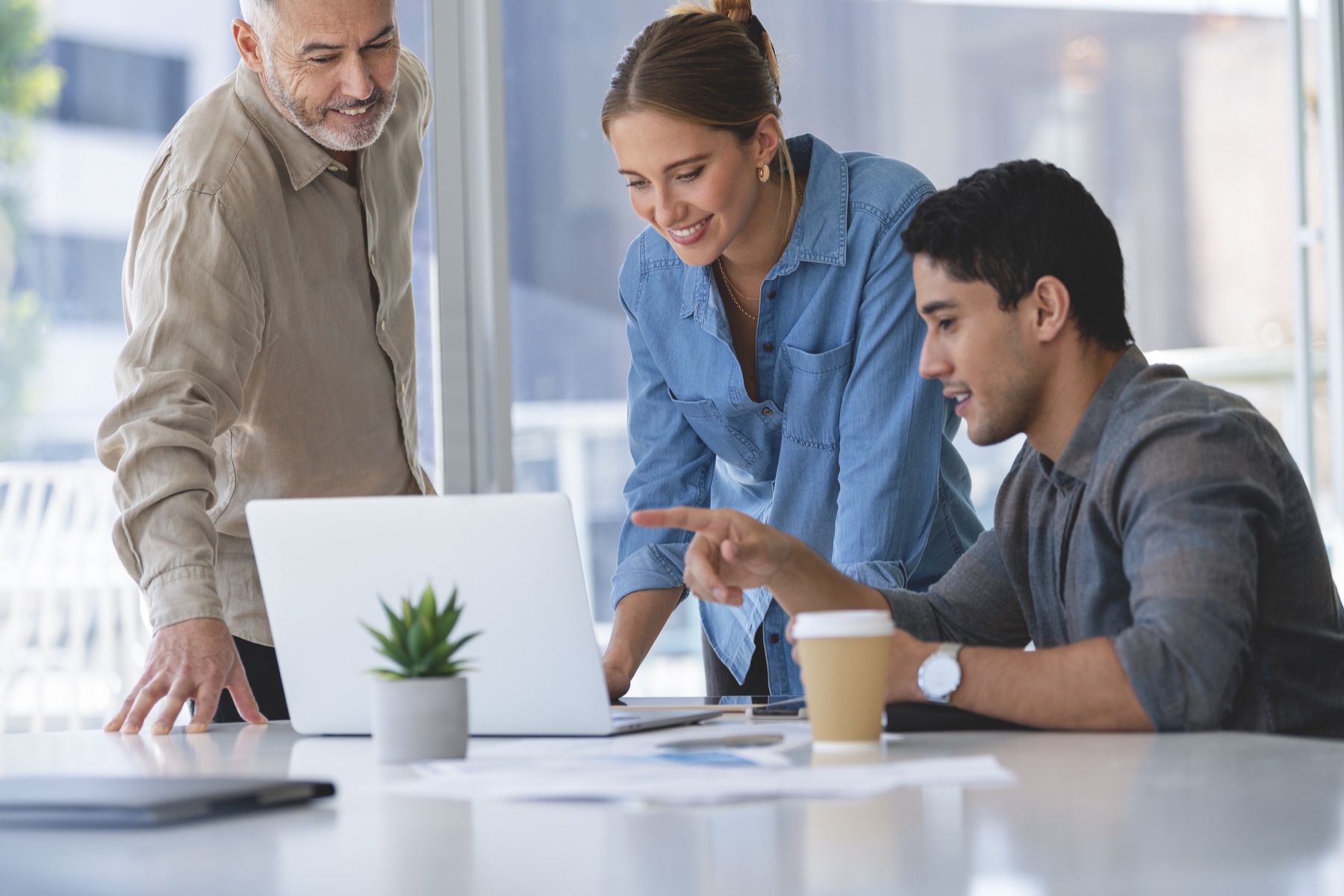 Finance professionals collaborating around a laptop